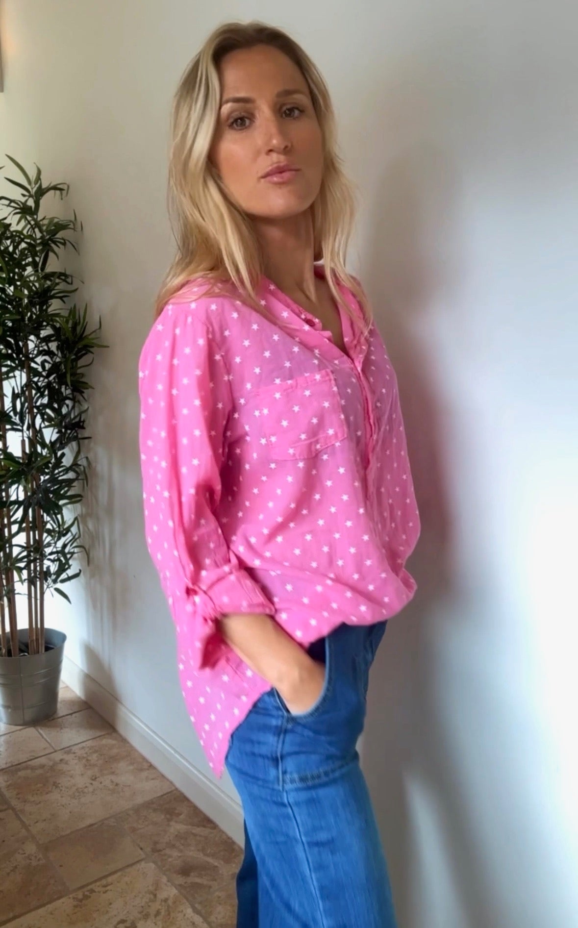 Side view of model in pink star print blouse highlighting relaxed fit and casual elegance