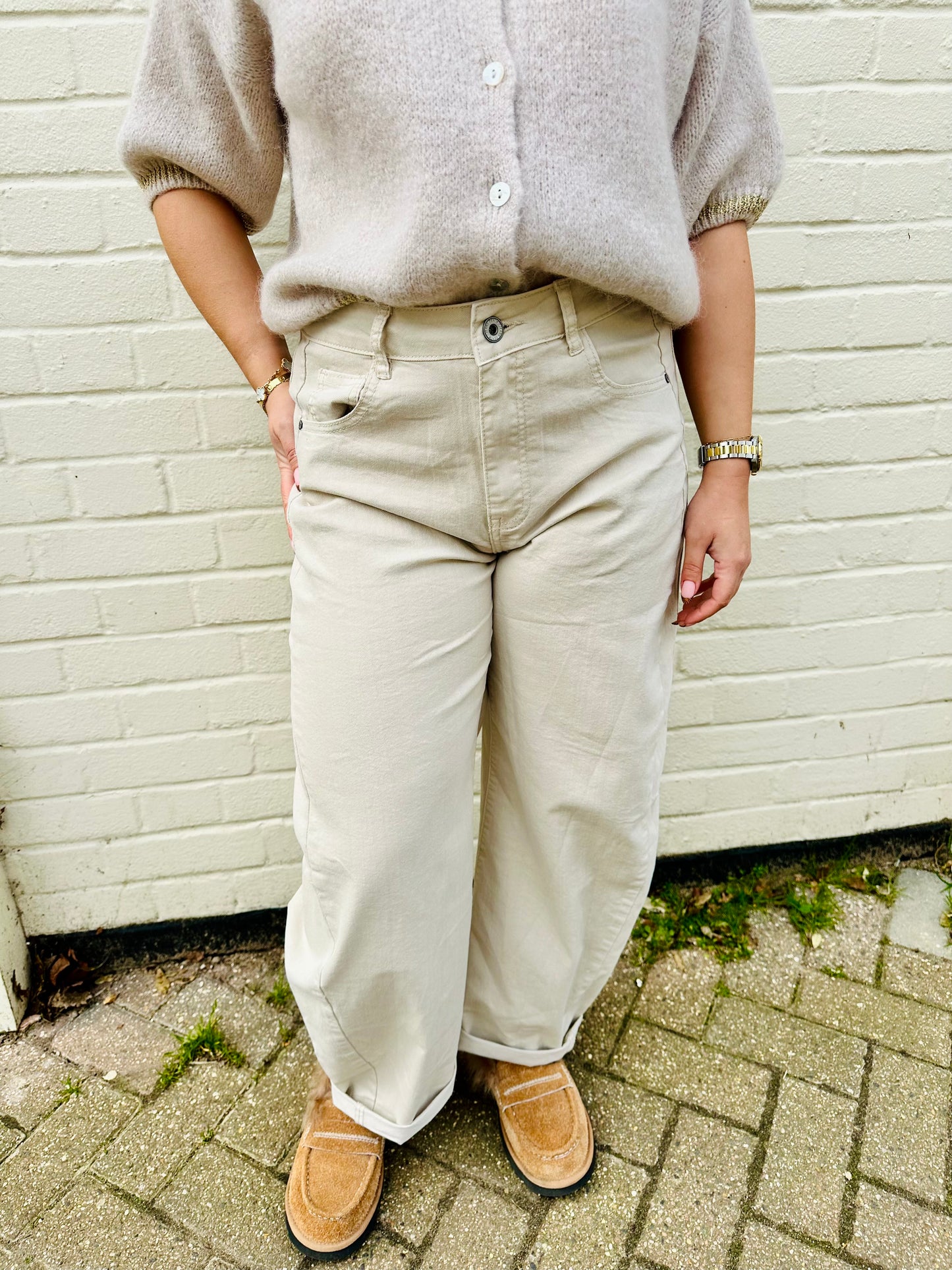 Woman wearing beige barrel leg jeans with high waist and cuffed hems