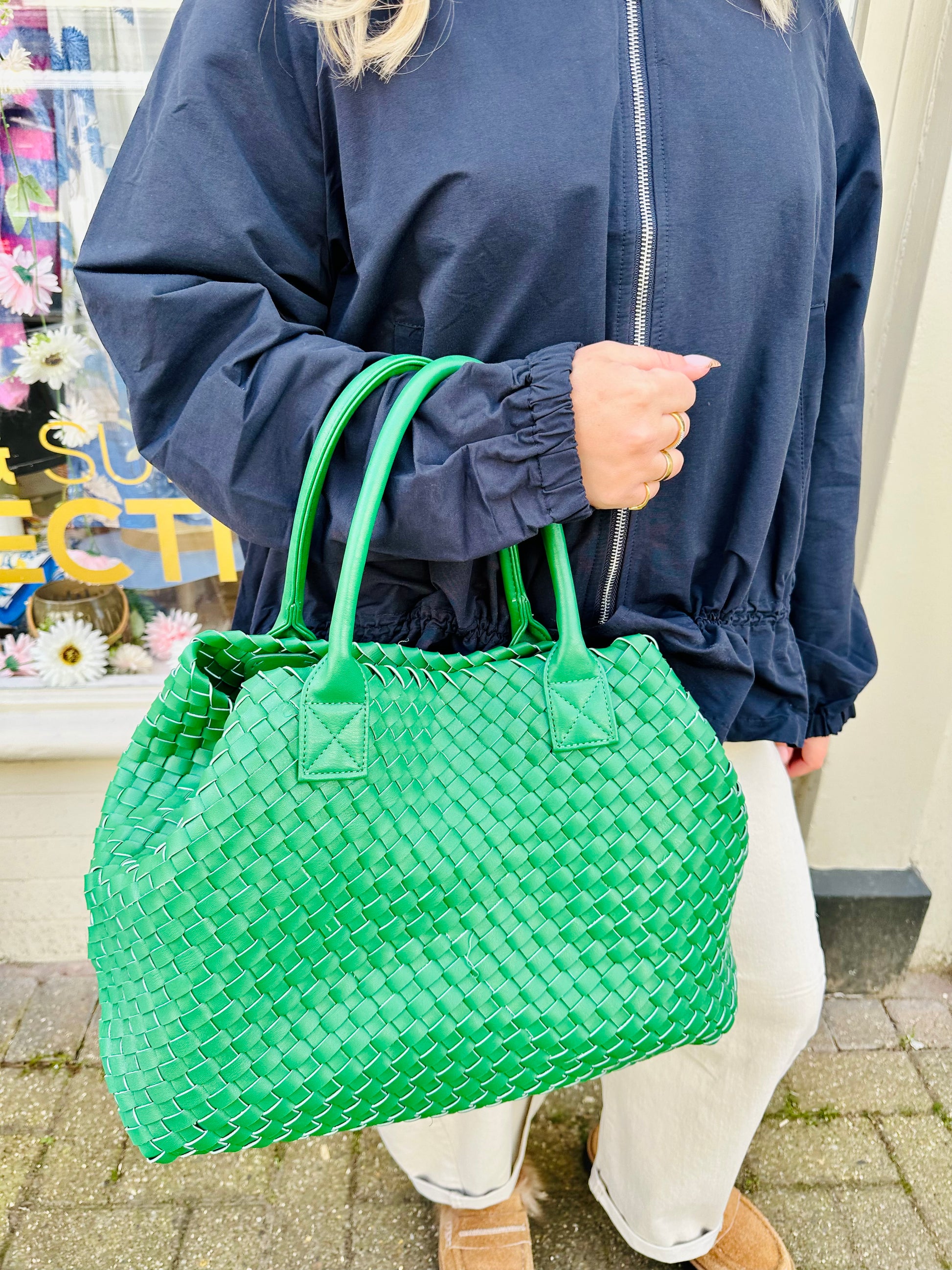 Woman holding vibrant green woven tote bag with sturdy dual handles