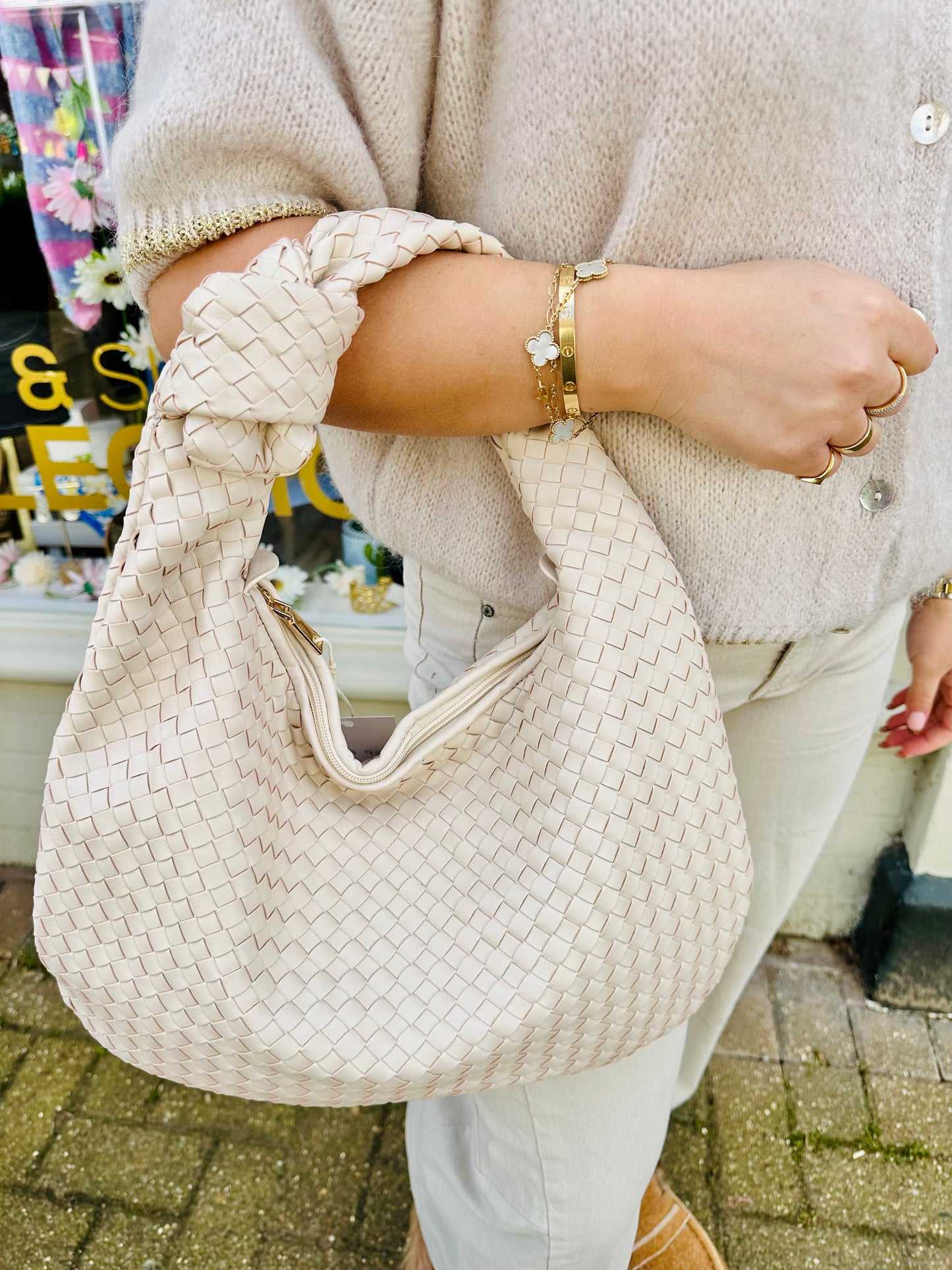 Cream woven Bottega inspired knot handle bag held on arm